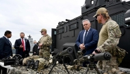 Australian Defence and Border Force officials brief Canadian Minister of Public Safety Gary Anandasangaree (L), US Secretary of Homeland Security Markwayne Mullin (2nd L), and New Zealand Police Minister Mark Mitchell (2nd R) on sniper rifles during a capability demonstration on Garden Island in Sydney on August 26, 2026, at an event held as part of the Five Country Ministerial (FCM) meeting. (Photo by Saeed KHAN / AFP)