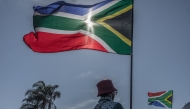 March and March Movement members wave South African flags as they protest outside the Durban International Convention Centre (ICC) under the theme 