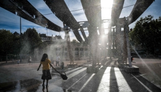 Pedestrians walk through water sprays on Place Bellecour during a heatwave in Lyon, central France on September 2, 2026. (Photo by OLIVIER CHASSIGNOLE / AFP)