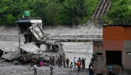 Security and relief personnel stand along the Trishuli riverbank in the aftermath of flash floods at Trishuli Bazar in Nepal's Nuwakot district on September 5, 2026. (Photo by Prakash MATHEMA / AFP)