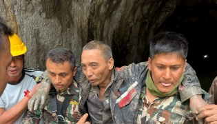 This handout photograph taken and released on September 5, 2026 via the Facebook page of Nepal Army shows security personnel carrying a Chinese national (2R) rescued from the Audit Tunnel 4 of the Upper Trishuli-1 Hydropower Project site in Nepal's Rasuwa district. (Photo by Handout / Nepal Army Facebook Page / AFP)