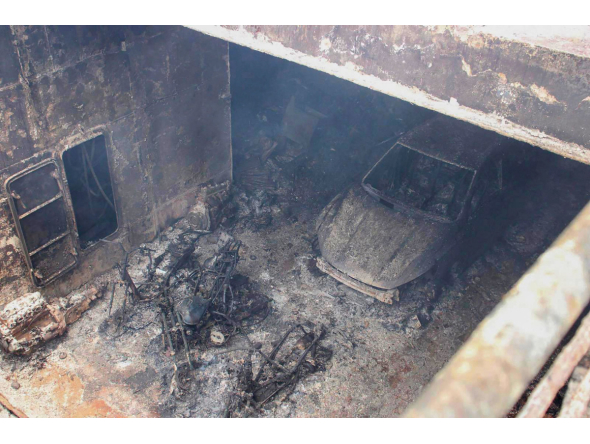 This handout photo taken on September 11, 2026 and released by the Philippine Coast Guard (PCG) shows a burnt vehicle and the burnt frames of motorbikes in the cargo hull of the M/V June Aster off the shores of Coron town, Palawan province. (Photo by Handout / Philippine Coast Guard (PCG) / AFP)