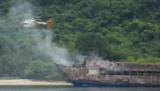 This handout photo taken on September 11, 2026 and released by the Philippine Coast Guard (PCG) shows a coast guard helicopter flying over the M/V June Aster ferry off the shore in Coron, Palawan province. (Photo by Handout / Philippine Coast Guard (PCG) / AFP)
