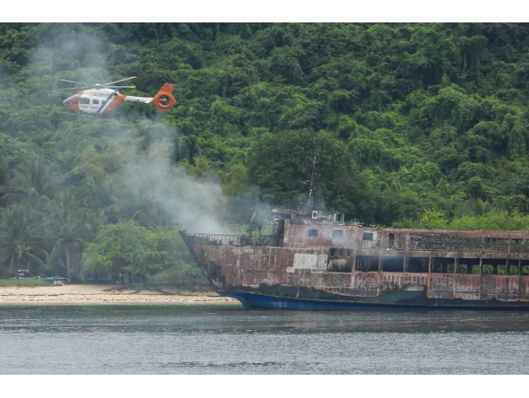 This handout photo taken on September 11, 2026 and released by the Philippine Coast Guard (PCG) shows a coast guard helicopter flying over the M/V June Aster ferry off the shore in Coron, Palawan province. (Photo by Handout / Philippine Coast Guard (PCG) / AFP)