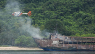 This handout photo taken on September 11, 2026 and released by the Philippine Coast Guard (PCG) shows a coast guard helicopter flying over the M/V June Aster ferry off the shore in Coron, Palawan province. (Photo by Handout / Philippine Coast Guard (PCG) / AFP)