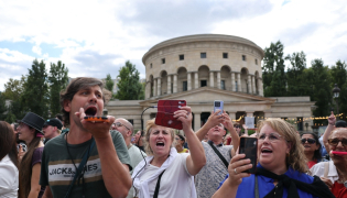 Fans of Canadian singer Céline Dion sing during a “Giant Karaoke” event in her honor in front of the La Rotonde Stalingrad monument in Paris on September 11, 2026, ahead of her concert on September 12. (Photo by Anne-Christine Poujoulat / AFP)