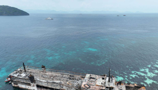 This handout photo taken on September 11, 2026 and released by the Philippine coast Guard (PCG), shows an aerial shot of the ill-fated M/V June Aster with coast guard personnel on board (bridge) off the shores of Coron town, Palawan province. (Photo by Handout / Philippine Coast Guard (PCG) / AFP)