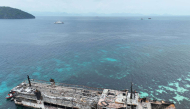This handout photo taken on September 11, 2026 and released by the Philippine coast Guard (PCG), shows an aerial shot of the ill-fated M/V June Aster with coast guard personnel on board (bridge) off the shores of Coron town, Palawan province. (Photo by Handout / Philippine Coast Guard (PCG) / AFP)