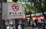People walk past a sign reading 