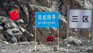 A rescuer from China Anneng observes the surrounding area when searching for survivors at the core affected zone of the mudslide-hit Gyirong Port in southwest China's Xizang Autonomous Region, Sept. 6, 2026. (Xinhua/Tenzin Nyida)