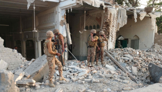 Army personnel stand amid the rubble following an explosion inside the police headquarters at Kohat in Pakistan's Khyber Pakhtunkhwa province on September 18, 2026. (Photo by Basit Shah / AFP)