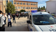 This handout photograph taken and released on September 22,2026 by Turkish news agency DHA (Demiroren News Agency) shows ambulances and police officers waiting in front of a high school outside which a gunman opened fire wounding eight people, and was detained shortly afterwards, in Turgutlu, an area west of the resort city of Izmir. (Photo by Handout / DHA (Demiroren News Agency) / AFP)