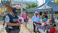 A member of the Mexican National Guard makes an announcement to residents and visitors about the approach of Hurricane Polo along a beach in Acapulco, Guerrero state, Mexico, on September 21, 2026. (Photo by Francisco Robles / AFP)