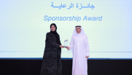 Assistant Undersecretary for Digital Industry Affairs Reem Mohammed Al Mansoori receives the award from UDST President Dr. Salem Al-Naemi during the ceremony.