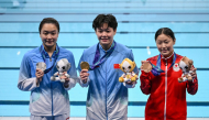Silver medallist China's Chen Jia (L), gold medallist China's Chen Yiwen (C) and bronze medallist Japan's Sayaka Mikami (R) pose following the victory ceremony of the women's 3m springboard final diving event. (Photo by Andrew Caballero-Reynolds / AFP)