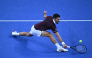 Novak Djokovic hits a return to Daniil Medvedev.