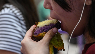 This photo taken on September 23, 2026 shows a customer eating an ube bibingka (baked rice cake) at a mall in Quezon City, Metro Manila. (Photo by Jam Sta Rosa / AFP) 