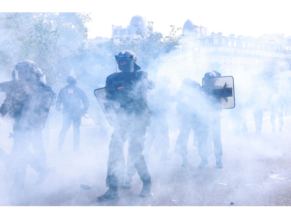 Police officers stand in the smoke during a demonstration of high-school students, in Paris on October 6, 2026, as part of a nationwide protest movement over learning conditions. (Photo by Kenzo TRIBOUILLARD / AFP)