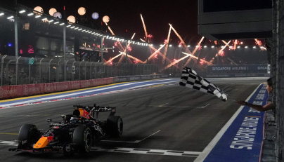 Red Bull Racing's Dutch driver Max Verstappen crosses the chequered flag at the finish line to win the Formula One Singapore Grand Prix at the Marina Bay Street Circuit in Singapore on October 11, 2026. (Photo by Ng Han Guan / POOL / AFP)