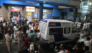 An ambulance carrying Durga Puja Pandal stampede victims stops in front of the emergency building of Calcutta Medical College and Hospitalas relatives of Durga Puja Pandal stampede victims mourn in Kolkata on October 16, 2026. (Photo by AFP)