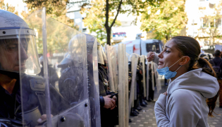 A protester faces riot police officers during an anti-government demonstration in central Tirana on October 20, 2026, after a week of violent anti-government protests. Photo by Adnan Beci / AFP