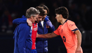 Barcelona's Spanish defender #12 Xavi Espart (R) comforts PSG's Georgian forward #07 Khvicha Kvaratskhelia leaving the pitch after sustaining an injury during the UEFA Champions League first round day 3 football match between Paris Saint Germain (PSG) and FC Barcelona at the Parc de Princes stadium in Paris on October 20, 2026. (Photo by FRANCK FIFE / AFP)
