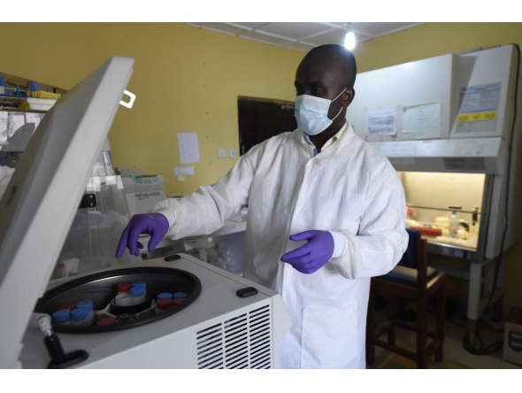 (FILES) A health official works in the laboratory extraction room of the Institute of Lassa Fever Research and Control in Irrua Specialist Teaching Hospital in Irrua, Edo State, midwest Nigeria, on March 6, 2018. (Photo by PIUS UTOMI EKPEI / AFP)