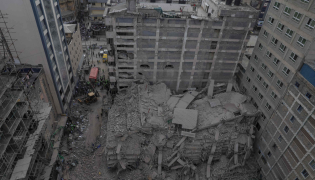 This aerial view shows personell from the Kenya Defence Forces Disaster Response Battalion inspecting the rubble of a collapsed residential building that was still under construction in the Eastleigh neighborhood of Nairobi on October 23,2026. Photo by Tony Karumba / AFP