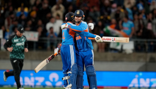 India's Abhishek Sharma (L) hugs teammate Vaibhav Sooryavanshi during the 3rd T20 cricket match between New Zealand and India. (Photo by Marty Melville / AFP)