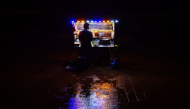 A vendor selling prawns waits for customers at the Galle Face seafront promenade, during a rainy night in Colombo on October 26, 2026. (Photo by Ishara S. KODIKARA / AFP)