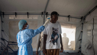 A health worker takes the temperature of a traveller after arriving in Bimbo district south-west of Bangui, on October 28, 2026. (Photo by AFP)
