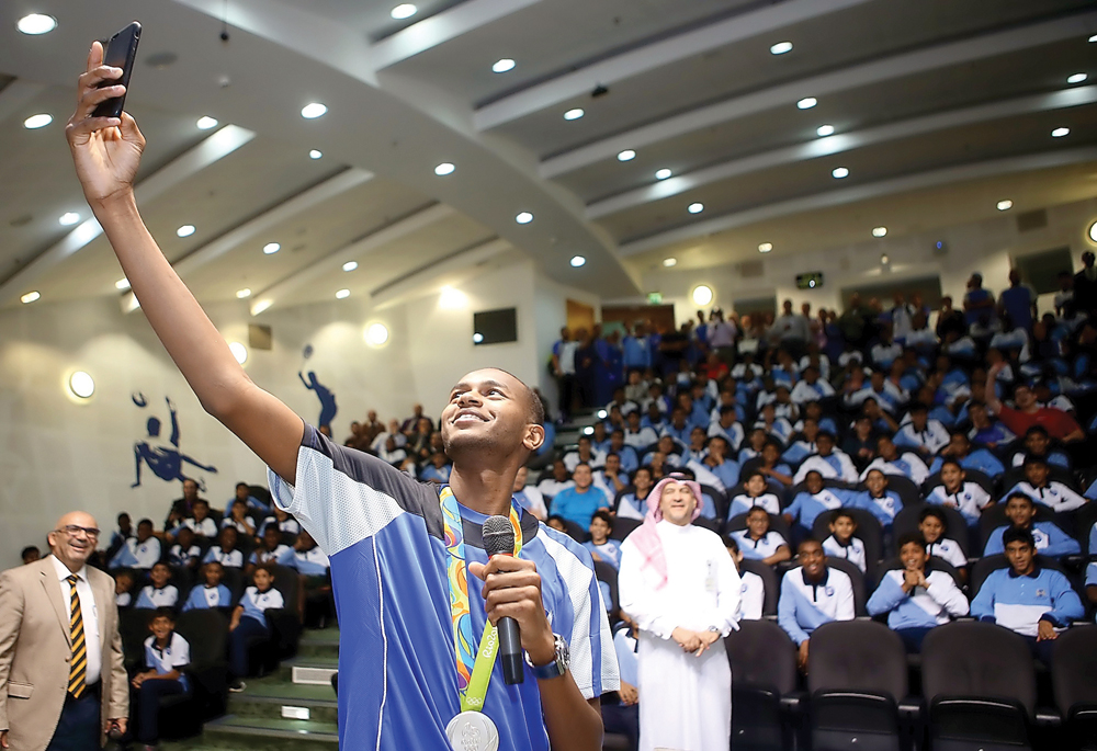 Star athlete Mutaz Essa Barshim takes a selfie with students and officials at the Aspire Academy yesterday. 