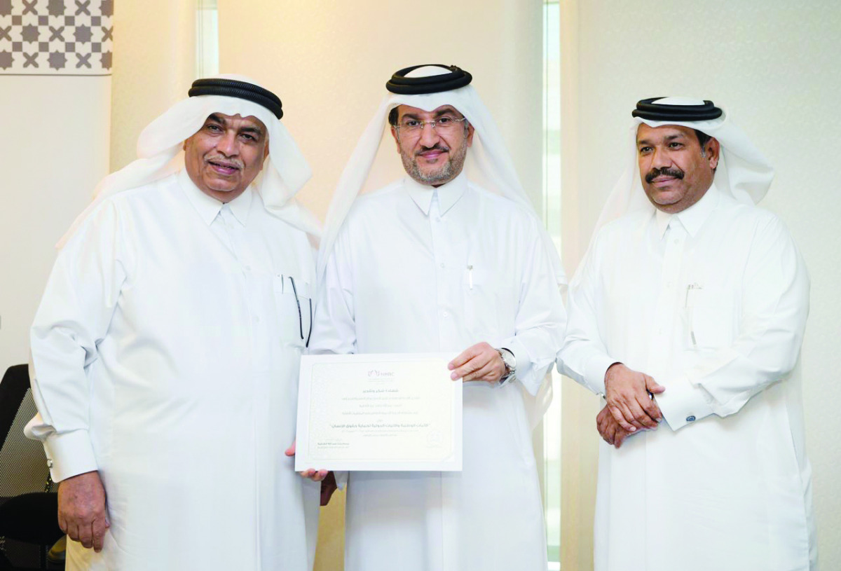 Dr. Abdulaziz Al Meghaiseeb (left), Member of NHRC, honouring one of the participants.