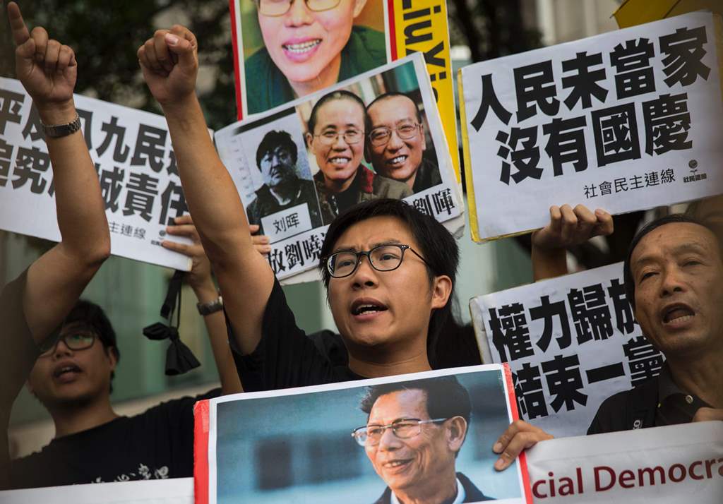 Raphael Wong (C), of the League of Social Democrats, chant slogans during a protest on China's National Day of celebrations in Hong Kong on October 1, 2016. AFP / ISAAC LAWRENCE
