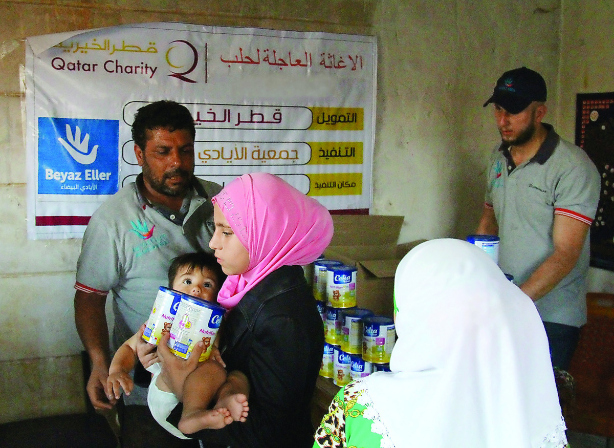 A woman receiving baby milk at a distribution centre set up by Qatar Charity in Aleppo.
