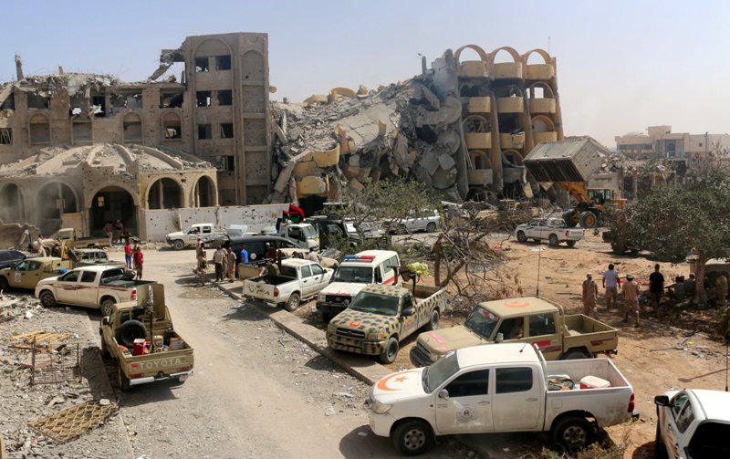 Libyan forces allied with the U.N.-backed government gather outside destroyed buildings they captured from Islamic State militants in neighbourhood Number Three in Sirte, Libya October 3, 2016. REUTERS/Hani Amara