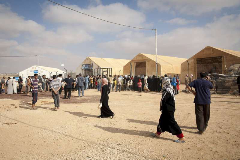 Syrian refugees wait at a UNHCR distribution centre in Za'atari refugee camp in Jordan. Photo: UNHCR/J. Tanner