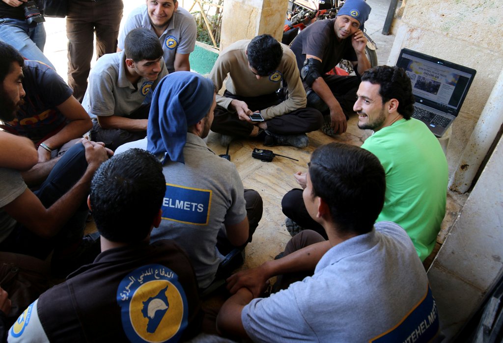 Civil Defence members, also known as the 'White Helmets', who have been nominated for the 2016 Nobel Peace Prize, gather around a laptop as they wait the announcemenet of the winner, in a rebel held area of Aleppo, Syria October 7, 2016. REUTERS/Abdalrhma