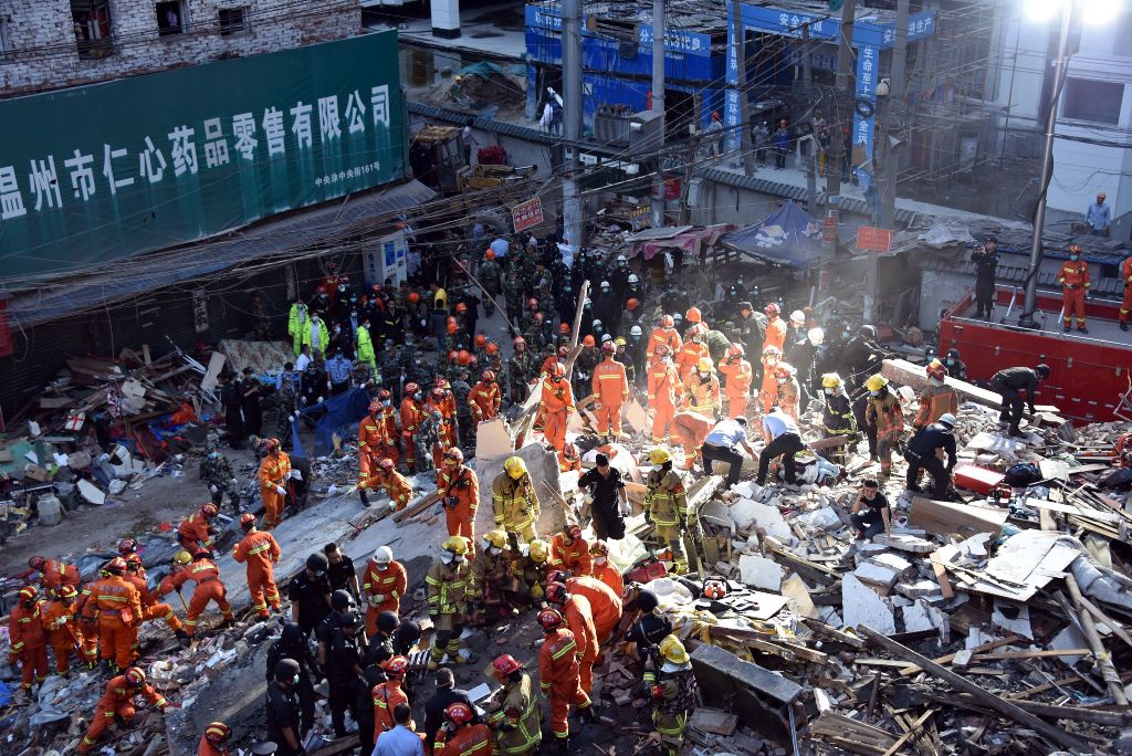 Rescuers search for survivors at an accident site after four buildings caved in during the early hours in Wenzhou, eastern China's Zhejiang province on October 10, 2016. Four people were killed when a group of houses collapsed in China on October 10, a lo