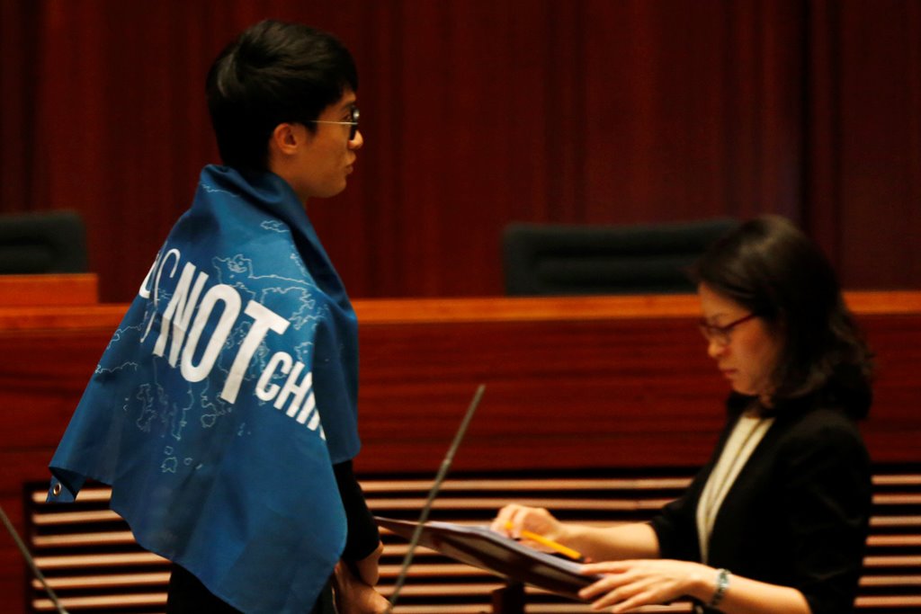 Newly-elected lawmaker Baggio Leung wears a banner 