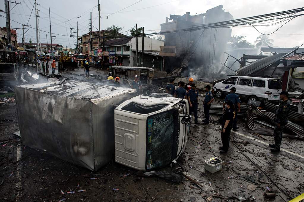 A truck was turned over after an explosion during a fire at fireworks shop in Bocaue, Bulacan, north of Manila on October 12, 2016. A fire that ripped through a group of fireworks shops in the Philippines has killed one person with another missing and six