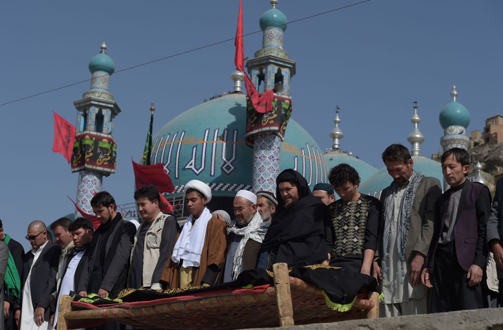 Afghan mourners offer funeral prayers for a victim in Kabul on October 12, 2016, who was killed in an attack by gunmen inside the Karte Sakhi shrine late on October 11.  / AFP / SHAH MARAI.