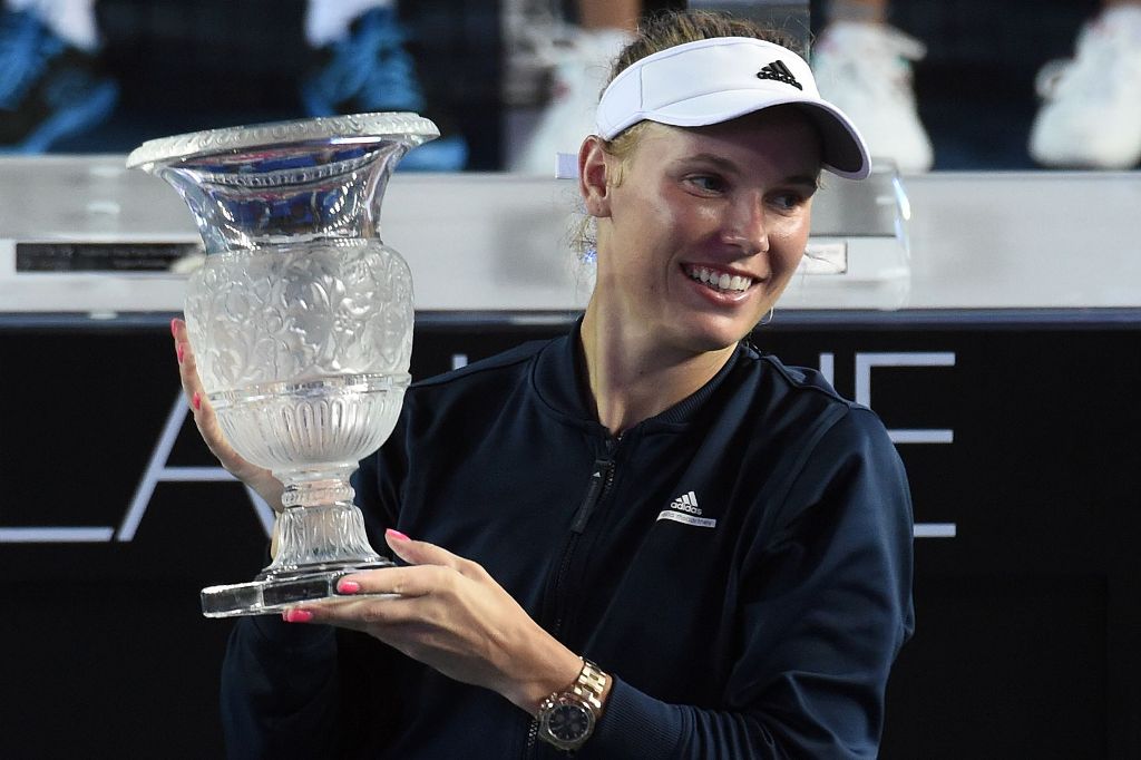 Denmark's Caroline Wozniacki holds the trophy as she celebrates victory against France's Kristina Mladenovic after their women's final match at the Hong Kong Open tennis tournament on October 16, 2016. / AFP / Anthony WALLACE
