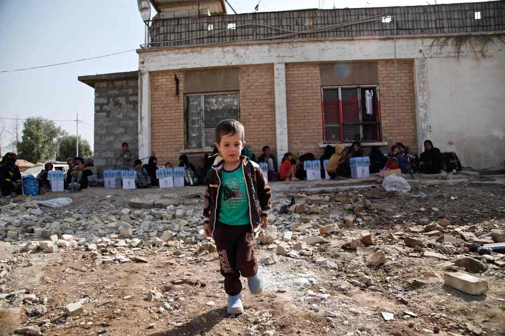 A handout picture release by Save The Children shows Ali, a five-year-old displaced Iraqi boy playing as they wait to be screened at the Dibis checkpoint northwest of the northern Iraqi city of Kirkuk on October 16, 2016 after they fled the Islamic State 