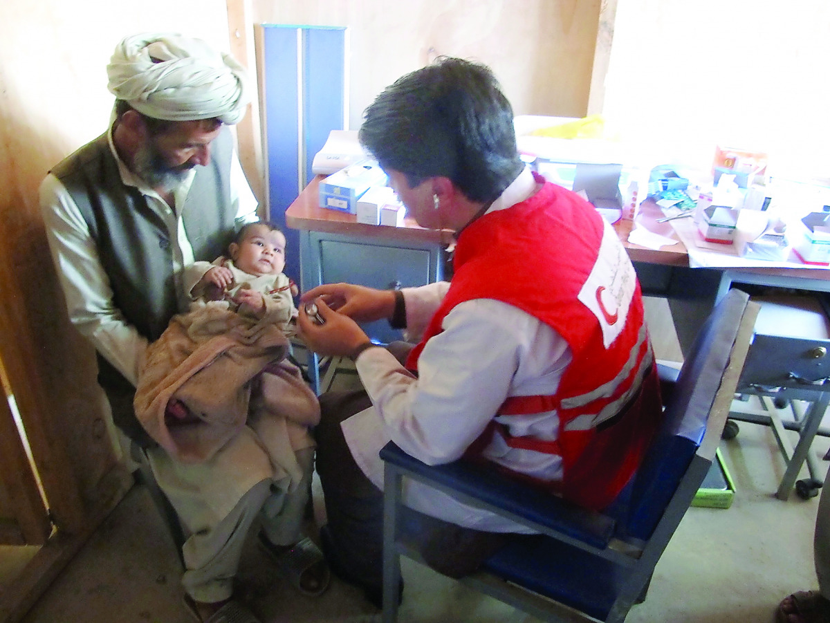 A child receives care at a health unit covered by a QRCS programme in Afghanistan. 