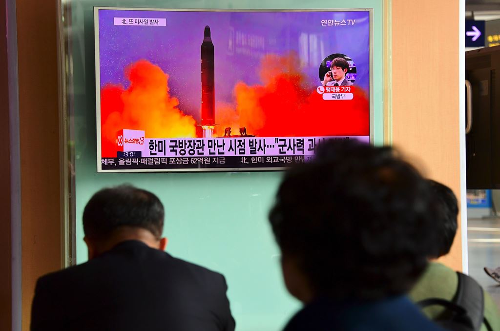 People watch a television news report showing file footage of North Korea's missile launch at a railway station in Seoul on October 20, 2016. AFP / JUNG YEON-JE