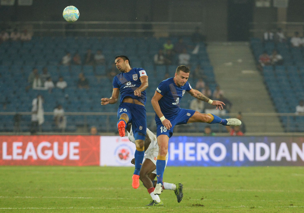 Mumbai City FC midfielder Sehnaj Singh (L) and Lucian Goian vies for the ball with Delhi Dynamos FC player during the Indian Super League (ISL) football match between Delhi Dynamos FC and Mumbai City FC at The Jawaharlal Nehru Stadium in New Delhi on Octo