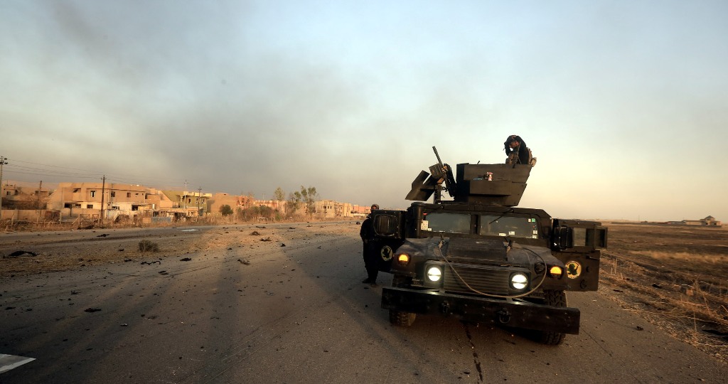 Smoke rises from a building as Iraqi soldiers take positions after retaking of Bartilla Town from Islamic State members during the operation to retake Iraq's Mosul, October 20, 2016.  Ali Mohammed - Anadolu Agency