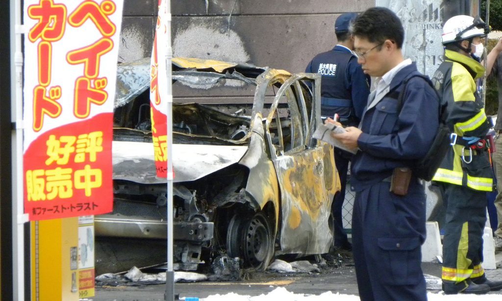 Policemen and firefighters investigate a parking lot after an explosion in Utsunomiya, where one person was found dead after blasts in a park. Photograph: Jiji Press/AFP/Getty Images