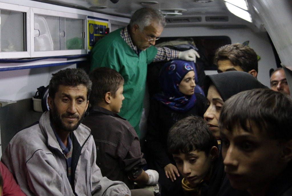 Syrians who were living in the rebel-held side of Aleppo are seen inside an ambulance after nearly 50 people fled the rebel held eastern districts of the battered city into the government-controlled west on October 24, 2016. AFP / GEORGE OURFALIAN
